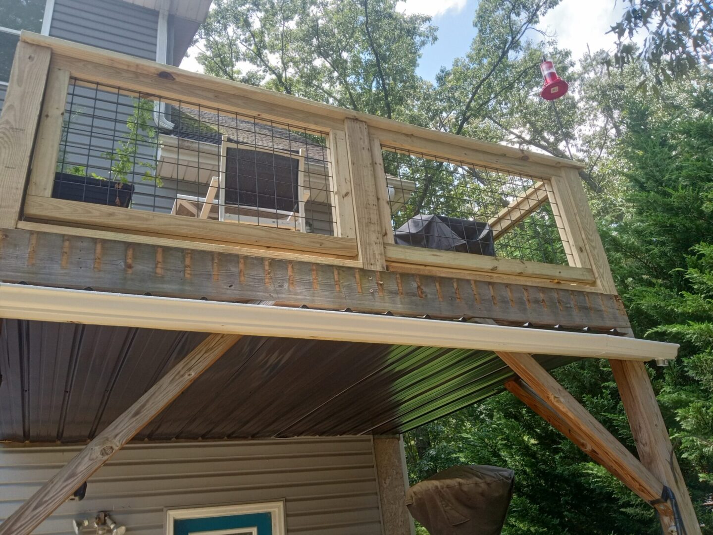 A deck with a railing and an open roof.