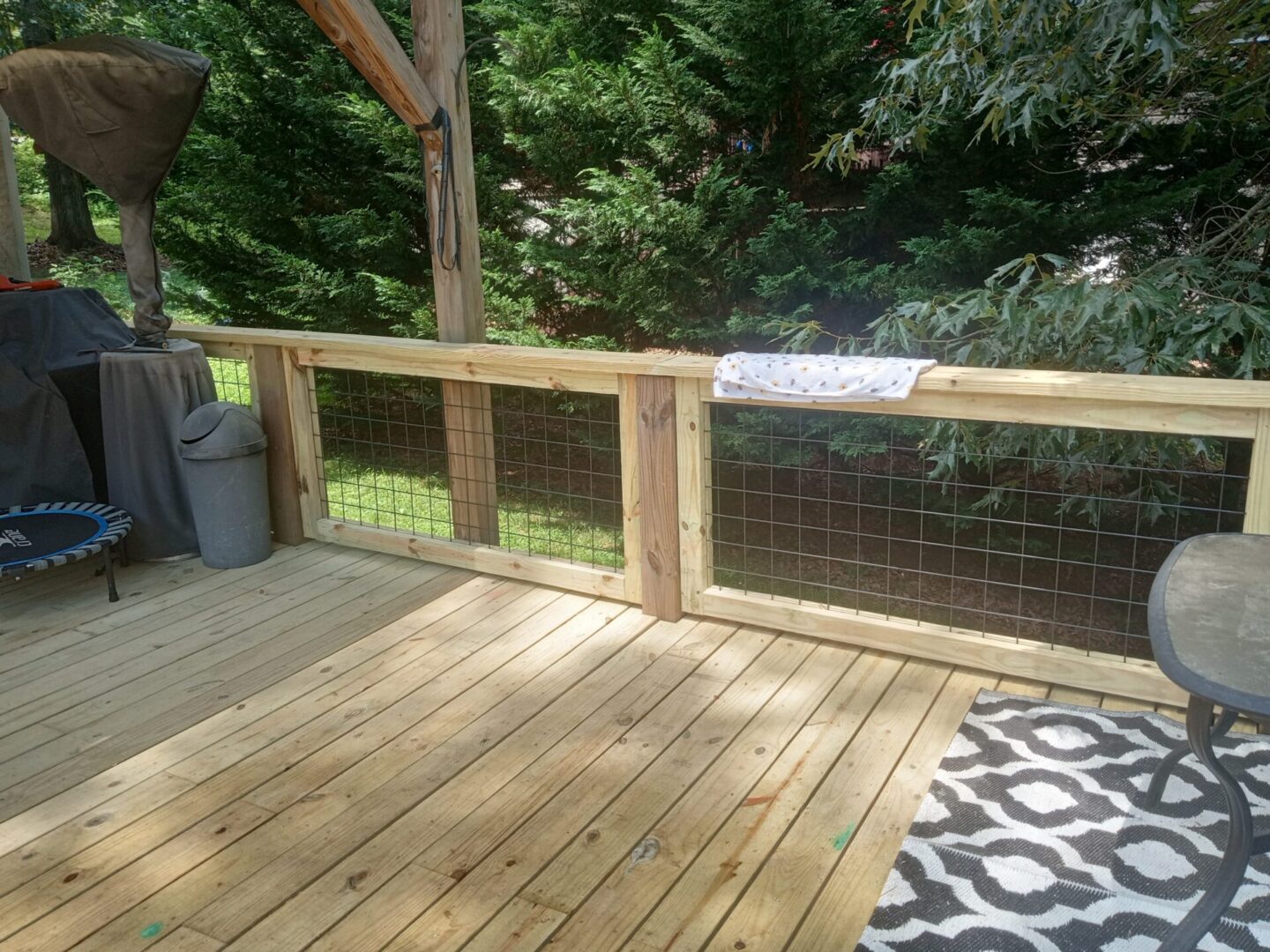 A wooden deck with a metal fence on the side.
